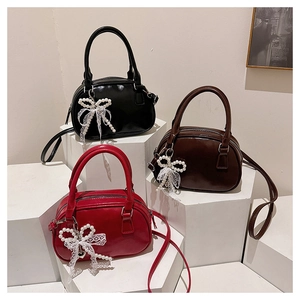 Three leather bowling bags in black brown and red with pearl lace bow charms