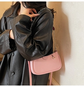 Detail of soft pink pebble leather underarm bag with gold chain and zipper closure