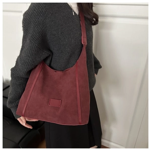 Detail of burgundy faux suede hobo bag showing soft matte texture and spacious design