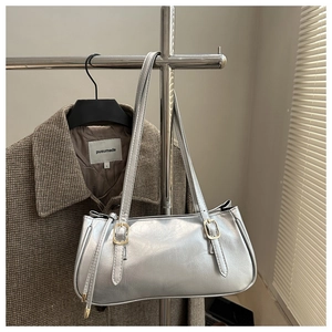 Detail of silver metallic shoulder bag with gold hardware on a coat hanger