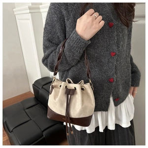 Close-up of retro bucket bag featuring canvas leather splicing and woven handle detail
