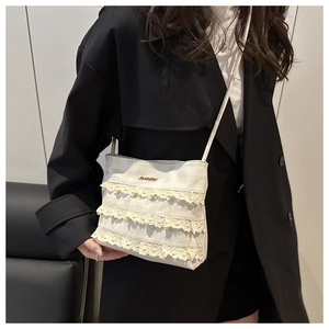 Close-up of cream lace mesh tote featuring layered ruffles on checkered fabric