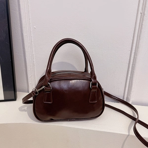 Deep brown glossy bowling handbag with top handles and adjustable shoulder strap