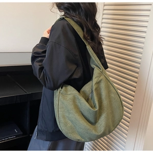 Detail view of large olive green slouchy tote bag with wide shoulder strap on model