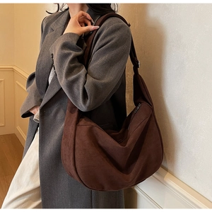Detail of dark brown suede crescent shoulder bag showing rich texture and slouchy shape