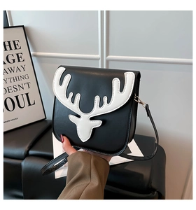 Gros plan du sac bandoulière carré noir avec patch bois de cerf blanc et boucles dorées