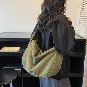 Olive green suede tote bag with crescent shape and large capacity shown on model