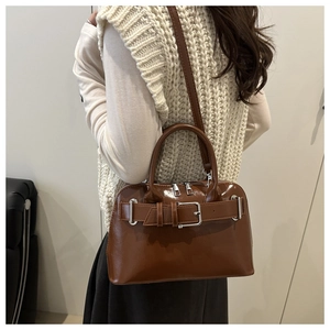 Brown glossy leather shell bag with decorative belt buckle and silver hardware details