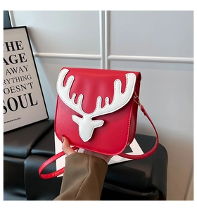 Détail d'un sac bandoulière rouge avec motif tête et bois de renne blanc décoratif