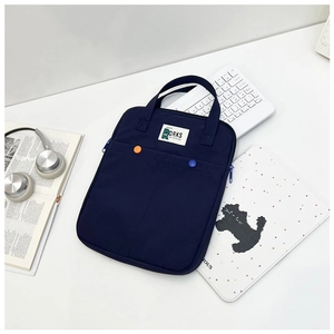 Detail van marineblauwe 14 inch laptoptas met logo-patch en gekleurde knoppen