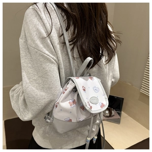 Kleiner weißer Rucksack mit Bären-Cartoon und Punkten, am Modell als Lifestyle-Foto