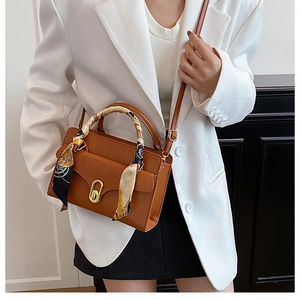 Brown PU leather crossbody bag featuring gold oval buckle and silk scarf handle detail