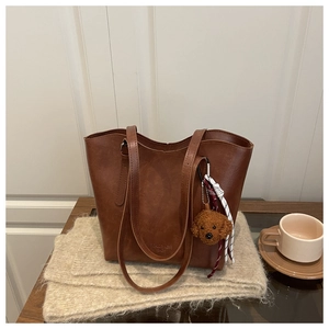 Détail d'un sac cabas marron texture vintage avec un charmant petit chien en peluche doux