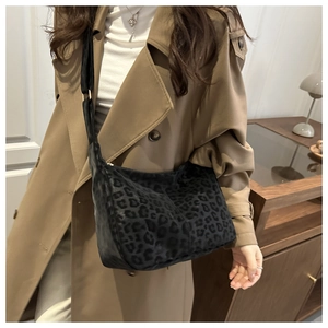 Detail showing high-capacity leopard print tote bag with soft texture and wide strap