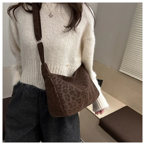 Detail of large brown leopard print tote bag featuring adjustable shoulder strap and canvas texture