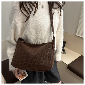 Detail of large brown leopard print tote bag with soft suede texture and shoulder strap