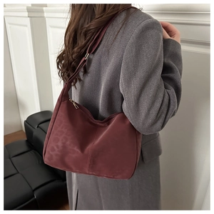 Dettaglio della borsa hobo bordeaux con stampa leopardata abbinata a cappotto grigio