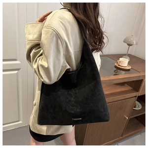 Dettaglio della borsa tote scamosciata nera con scritta fashion e texture opaca