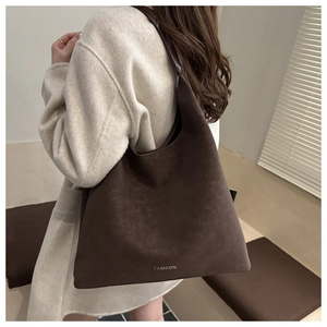Grande borsa hobo in camoscio caffè scuro con scritta Fashion bianca sul modello