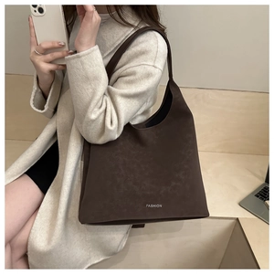 Gros plan d'un grand sac cabas en daim marron avec inscription FASHION à l'épaule
