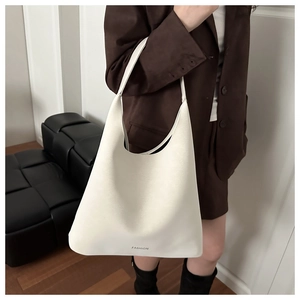 Dettaglio di una borsa hobo minimalista in pelle bianca con logo fashion su un modello