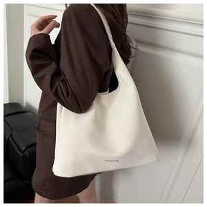 Gros plan détaillé d'un sac cabas blanc avec logo FASHION et texture cuir subtile