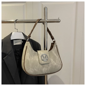 Detail of hobo bag featuring silver M-logo buckle and vintage washed texture strap