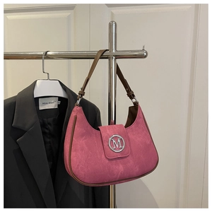 Detail of pink crescent bag showing suede texture, brown trim and silver M logo