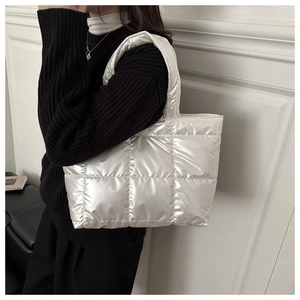 Detailed view of silver quilted tote bag with metallic finish and padded nylon texture