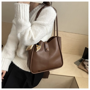Close-up of brown leather tote bag with decorative silk scarf on a model for daily use