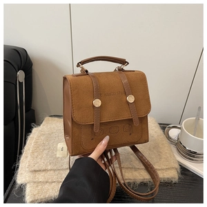 Detail of vintage brown backpack with flap suede texture and animal embossed design