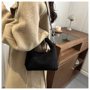 Détail du sac hobo en peluche noire avec bandoulière en cuir et boucles argentées