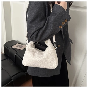Close-up of white plush crossbody dumpling bag with lamb wool texture and metal clasp