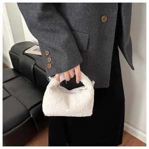 Close-up of soft white plush handbag with top zipper detail for autumn and winter