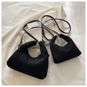 Detail of black faux shearling bags in two sizes with slim leather straps and silver buckles
