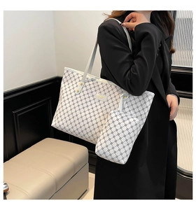 Dettaglio della borsa tote bianca con motivo floreale nero e pochette coordinata
