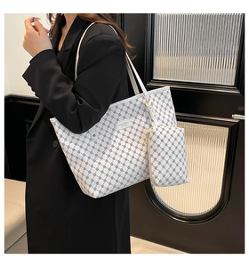 Detail of white tote bag set with black geometric pattern on a fashion model