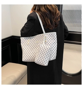 Detail of white geometric tote bag with matching pouch shown on a black winter coat