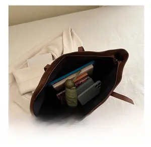 Large capacity brown leather tote bag showing interior space for books and tablet