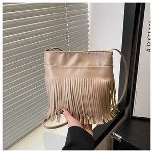 Detail der beigen Leder-Eimertasche mit langen Fransen und dünnem Schultergurt