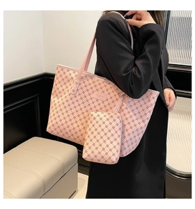 Detail of pink monogram tote bag with textured leather surface and mini pouch accessory