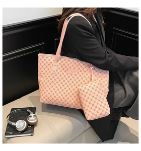 Dettaglio della borsa tote rosa con motivo a quadrifoglio, bustina e patch in pelle logo