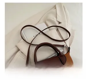 Detail of the brown textured handbag showing silver metal hardware and leather handle
