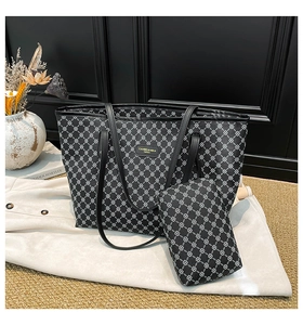 Dettaglio della borsa tote nera con motivo geometrico e set di pochette abbinate