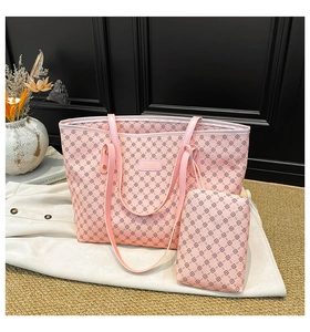 Dettaglio della borsa tote rosa con pochette coordinata e motivo a quadrifoglio elegante