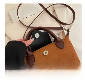 Detail of magnetic silver closure and brown leather interior on caramel crossbody bag