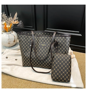 Vista dettagliata della borsa tote marrone scuro con motivo a trifoglio e pochette