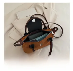 Detail view of brown suede mini tote interior with dual magnetic and zipper closure