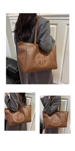 Close-up of vintage brown large tote bag with lychee texture and round logo detail