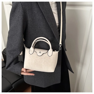 Close-up of beige nylon dumpling bag with leopard print showing handles and shoulder strap